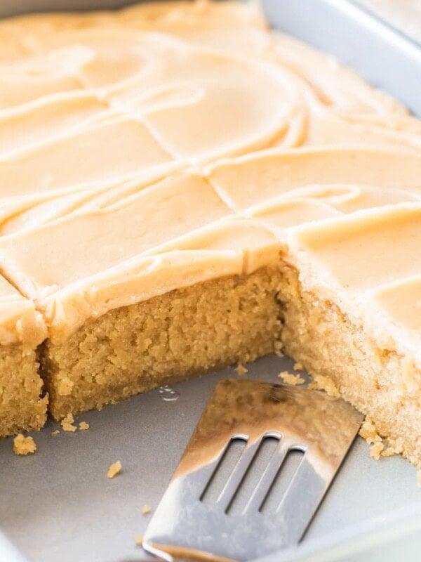 Peanut butter sheet cake that's been frosted and sliced in its pan.
