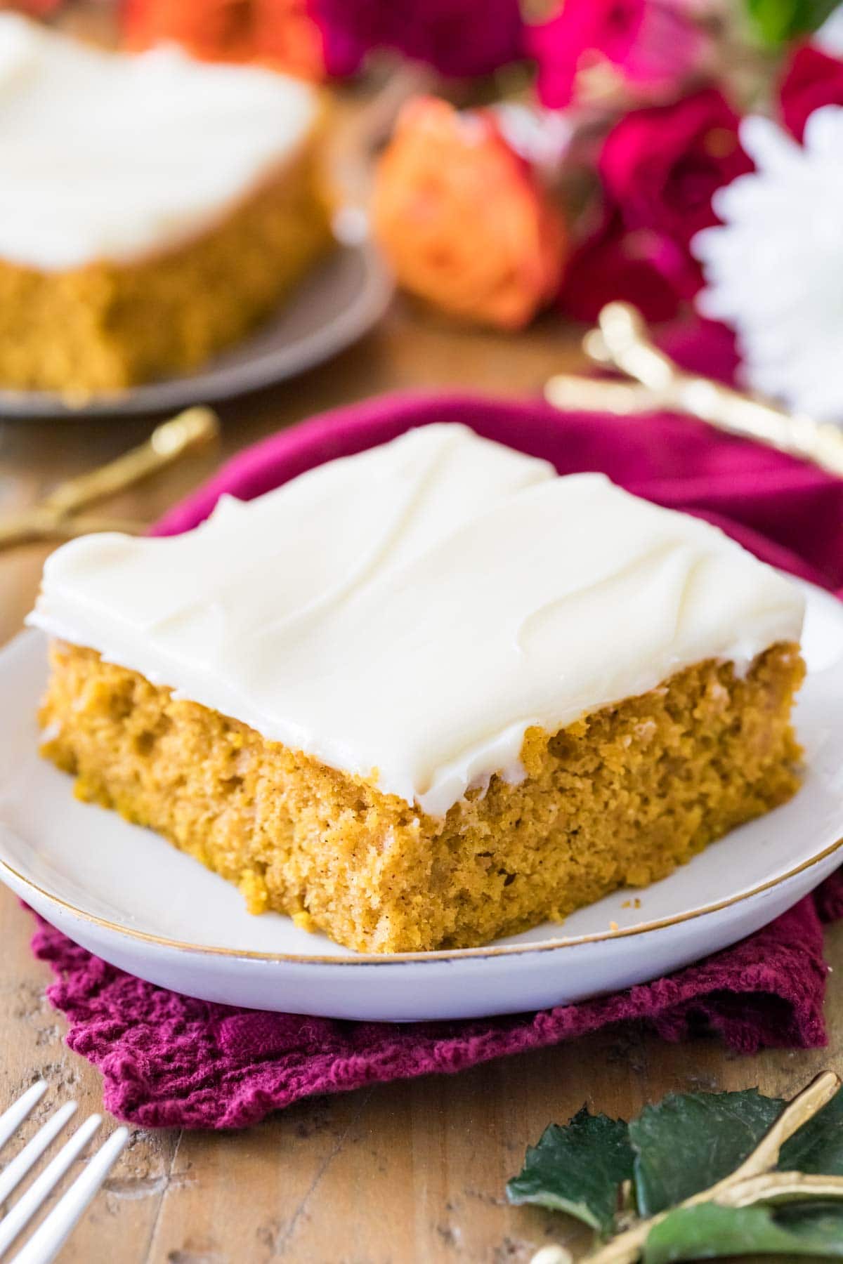 Pumpkin bar frosted with cream cheese frosting on a white plate.