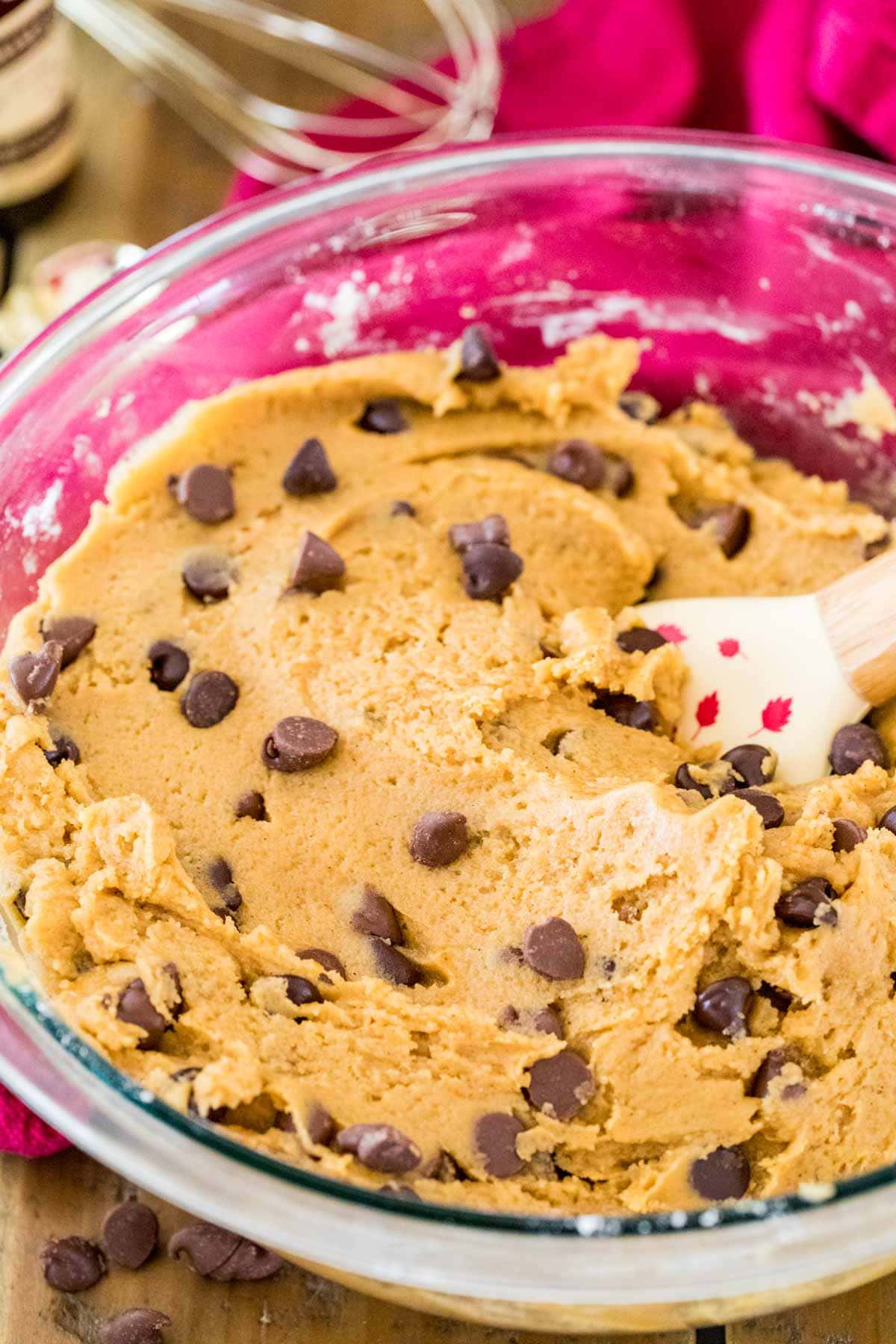 Pumpkin cookie dough with chocolate chips being stirred into it.