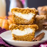 two halves of a pumpkin cream cheese muffin stacked on top of each other to show their cheesecake centers