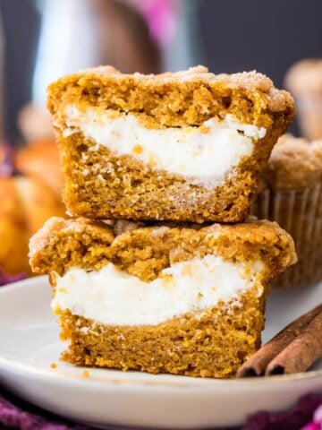 two halves of a pumpkin cream cheese muffin stacked on top of each other to show their cheesecake centers