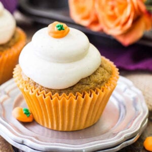 pumpkin cupcake topped with a brown sugar cream cheese frosting and a pumpkin candy