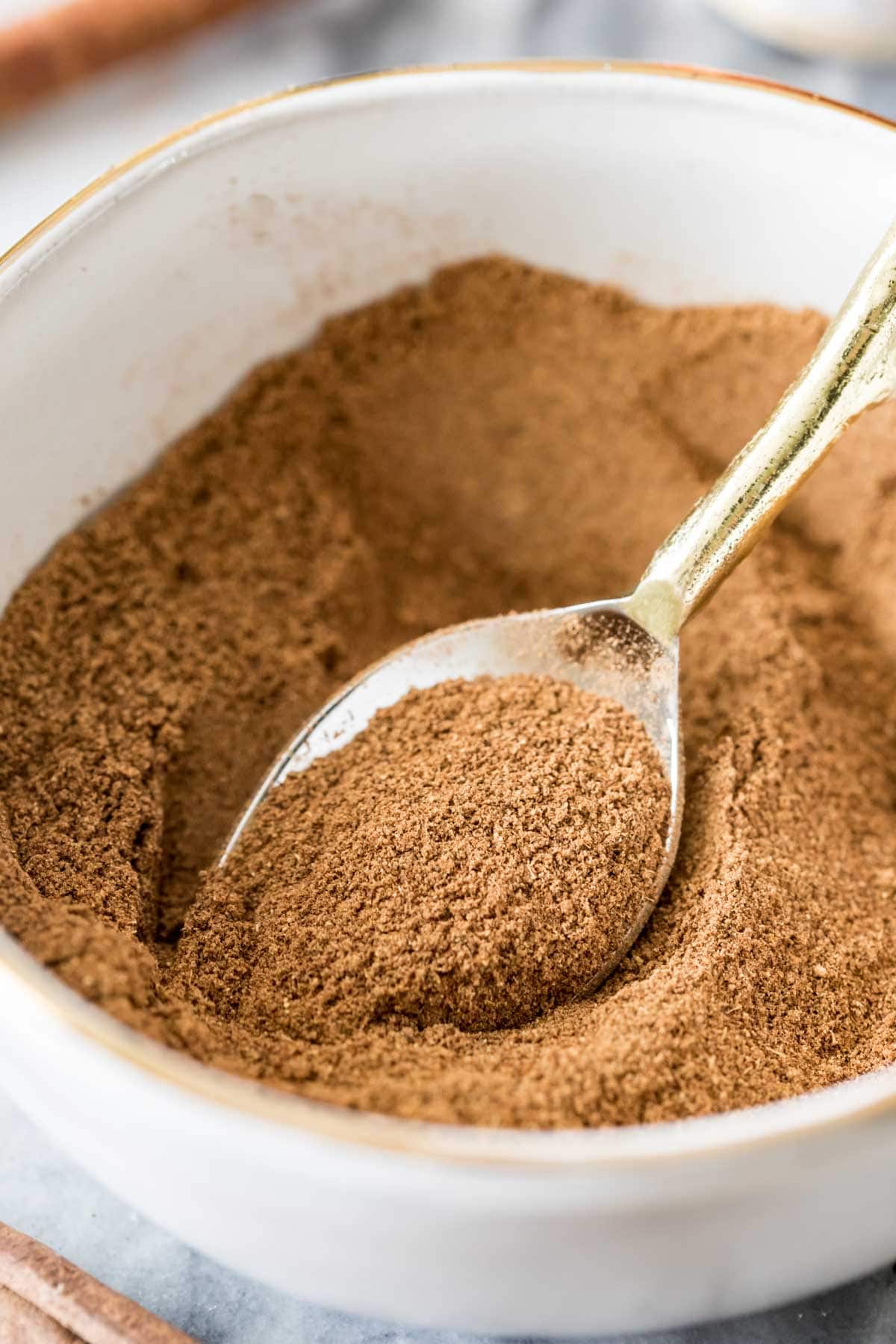 spoon scooping out homemade pumpkin spice from a bowl