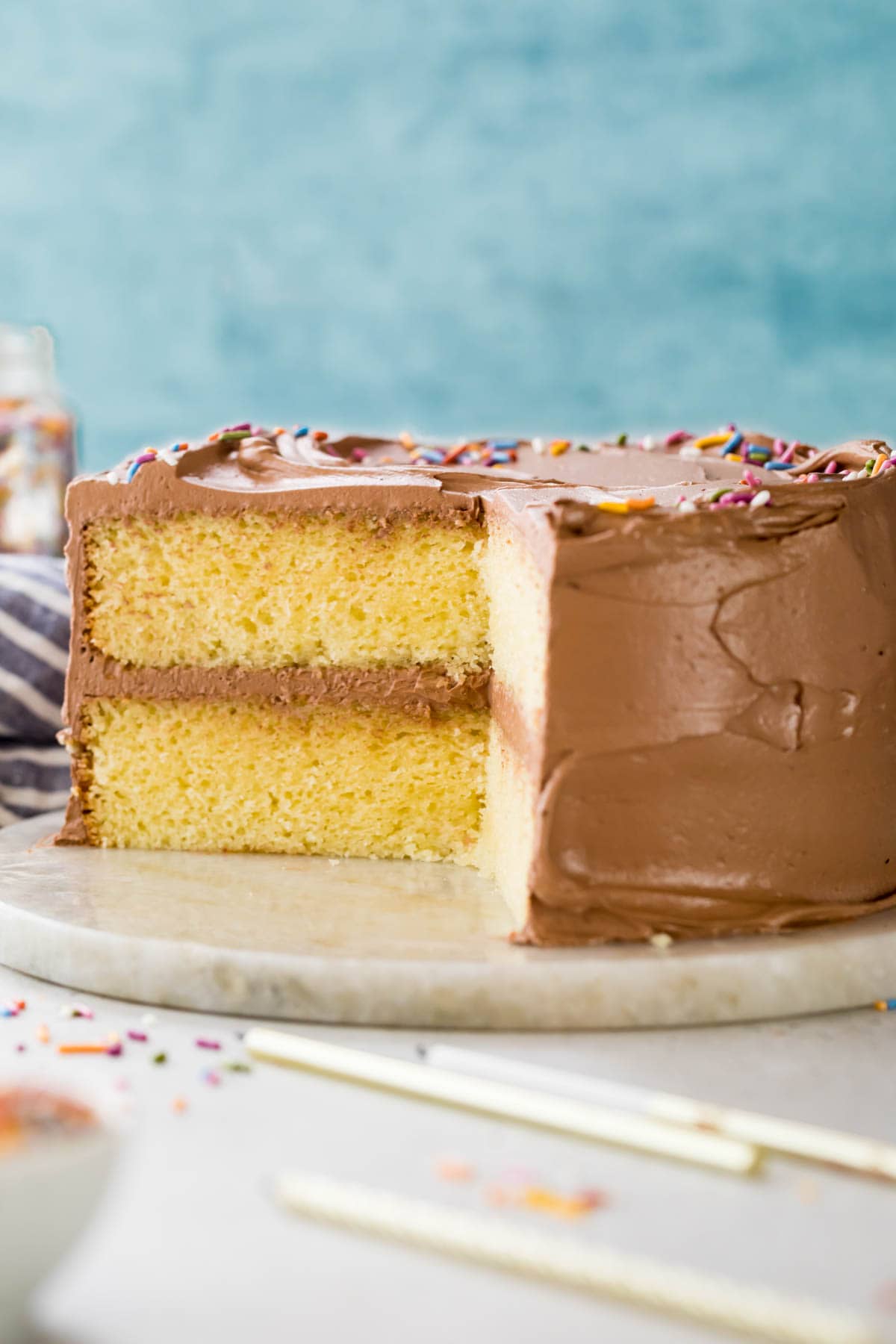 Cross section of a yellow cake frosted with chocolate frosting.