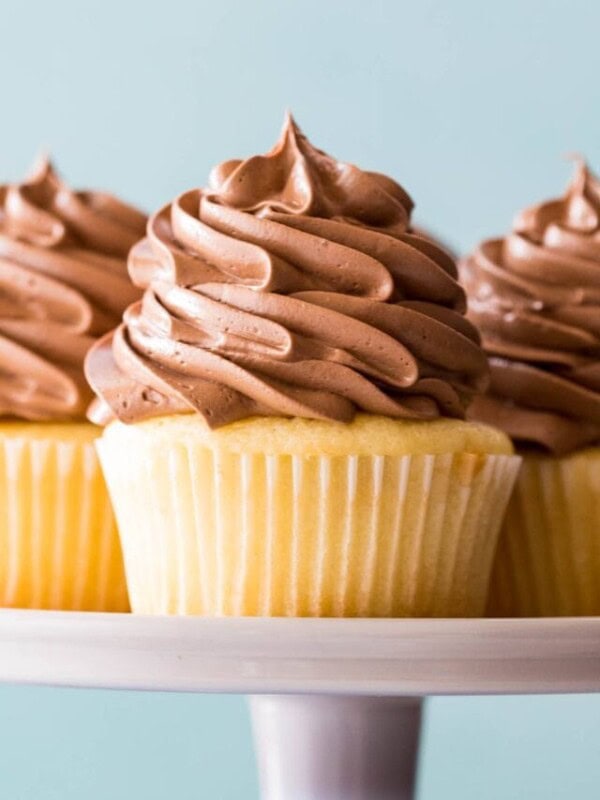 close-up of three cupcakes piled high with fluffy chocolate buttercream