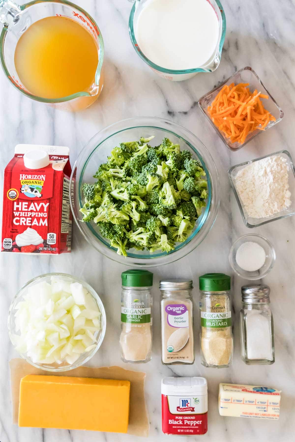 Overhead view of ingredients including broccoli, shredded carrots, cheddar cheese, and more.