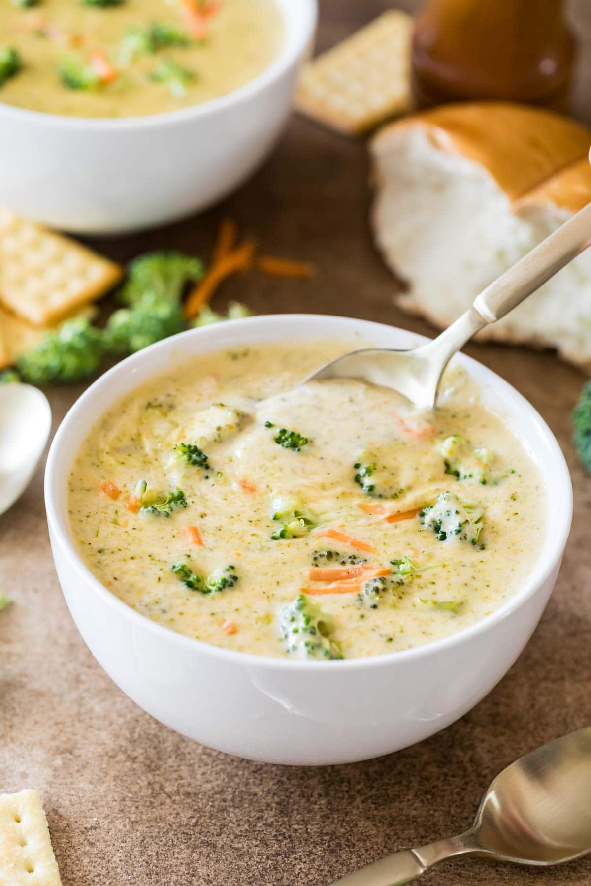 Bowl of broccoli cheddar soup with a spoon scooping out a bite.