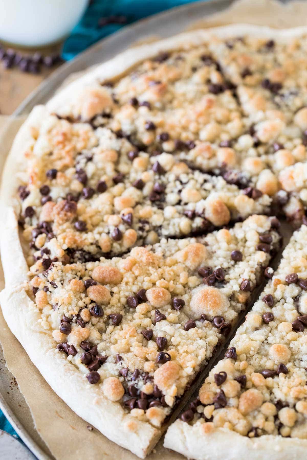 Sliced chocolate chip dessert pizza topped with streusel.