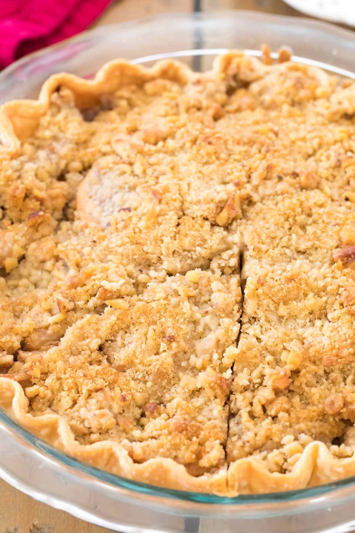 Overhead view of a slice of crumb-topped apple pie before being removed from the pie plate.