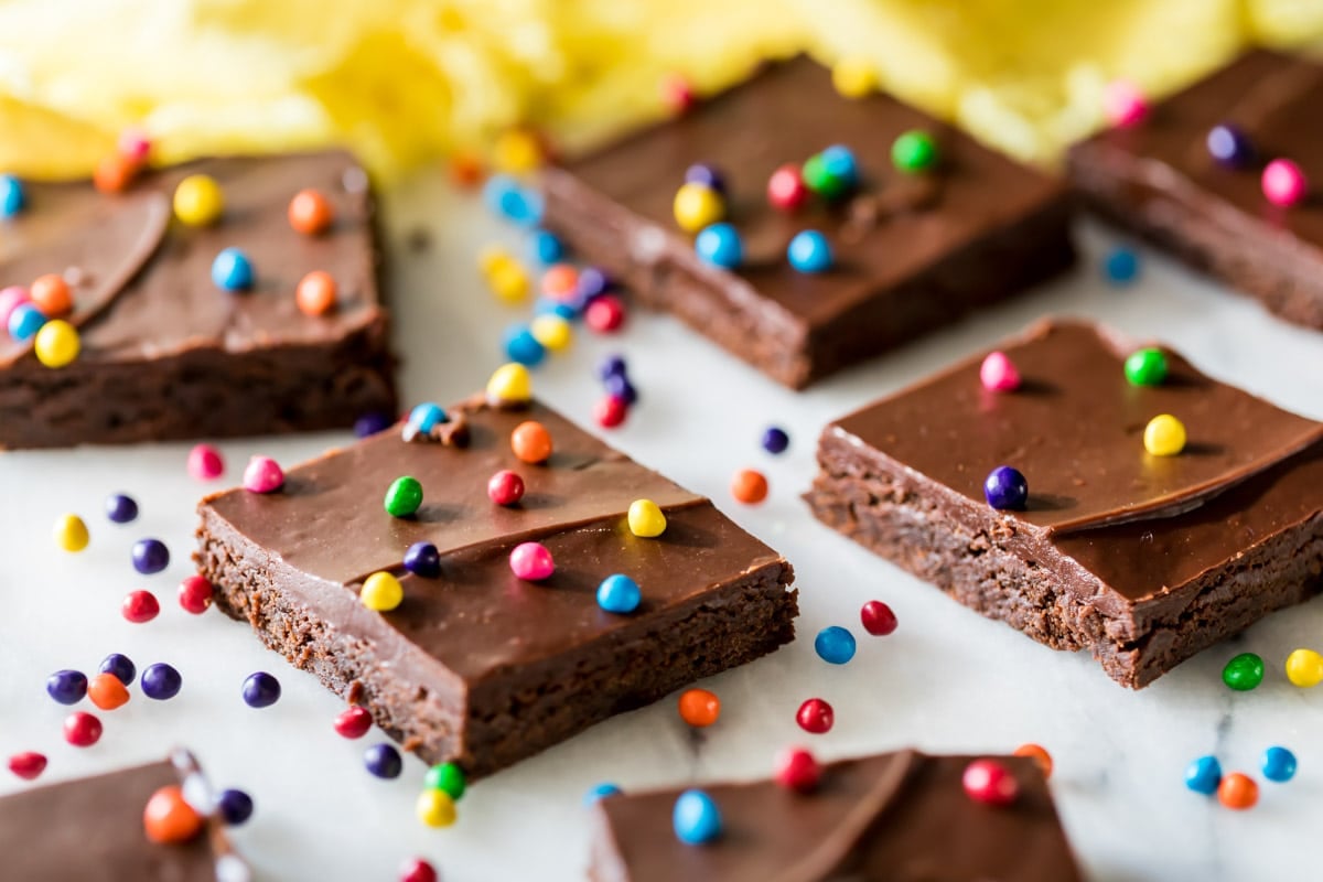 Squares of chocolate frosted brownies made from a cosmic brownie recipe.