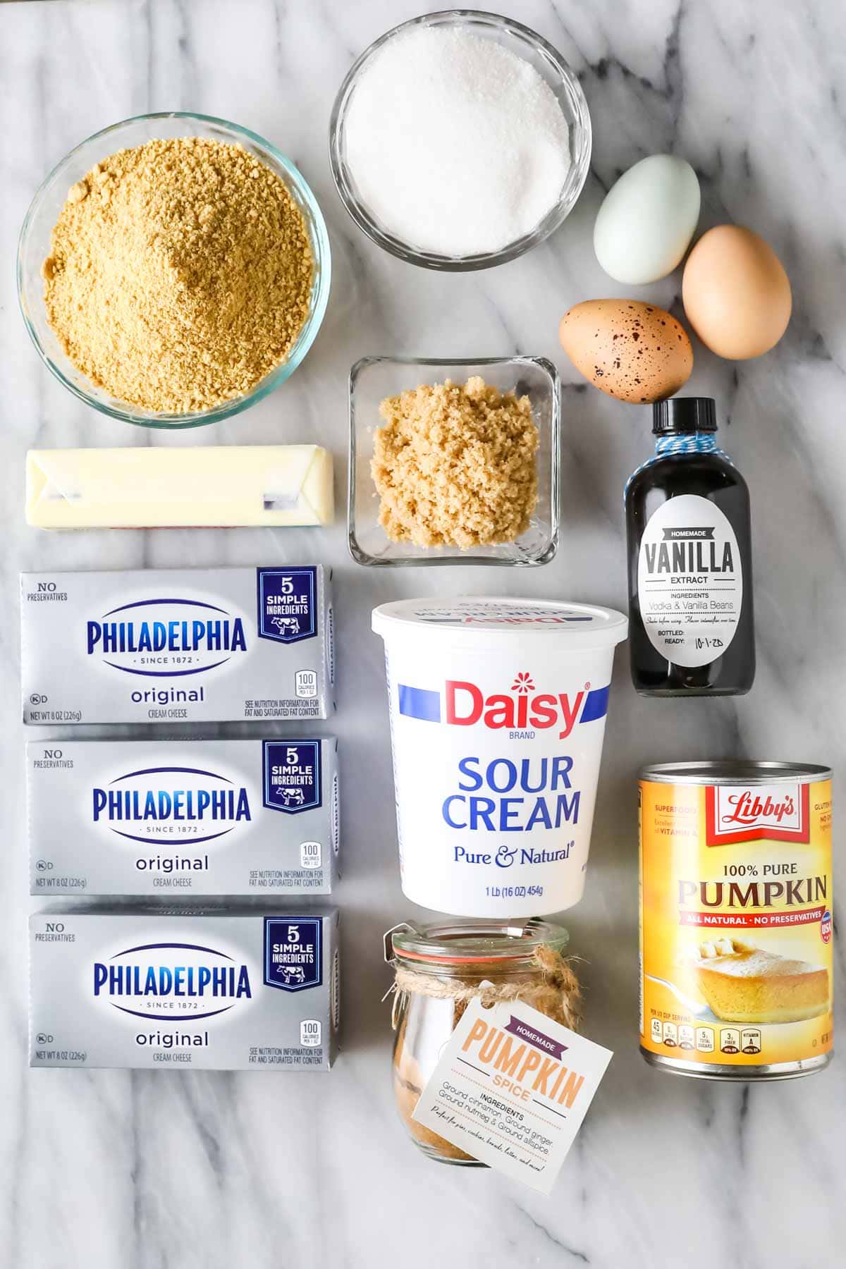 Overhead view of ingredients including cream cheese, pumpkin, sour cream, and more.