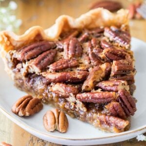 Slice of pecan pie on a white plate.