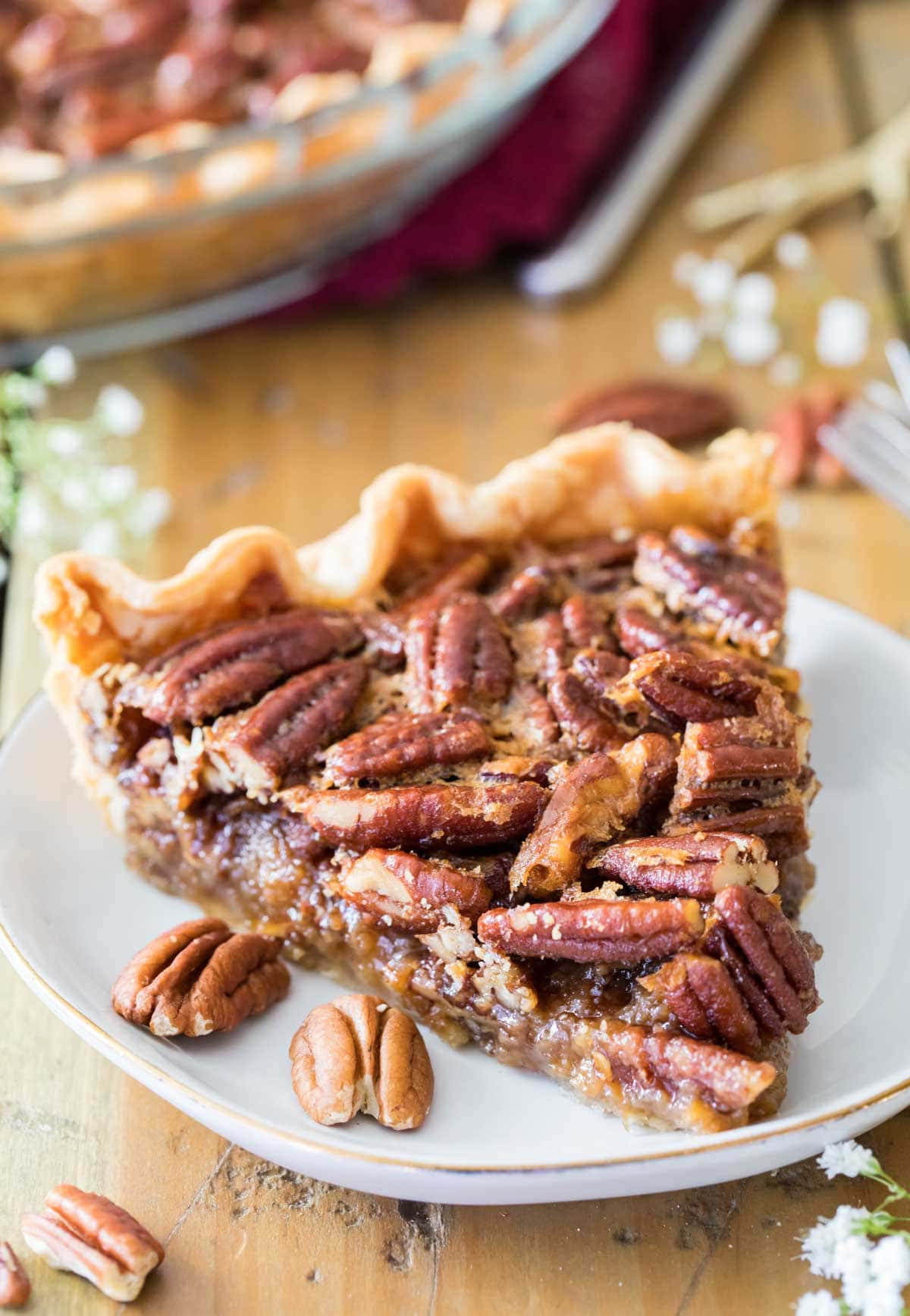 Slice of pecan pie on a white plate.