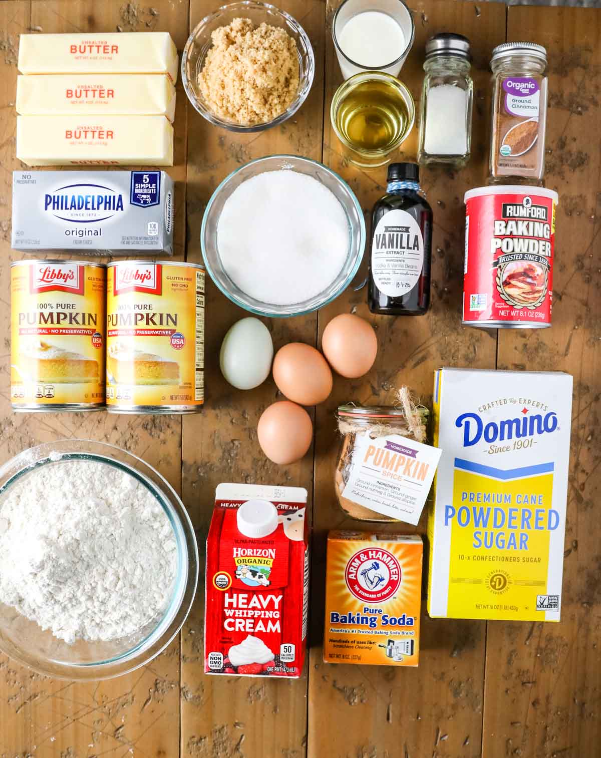 Overhead view of ingredients including pumpkin puree, brown sugar, butter, cream cheese, and more.