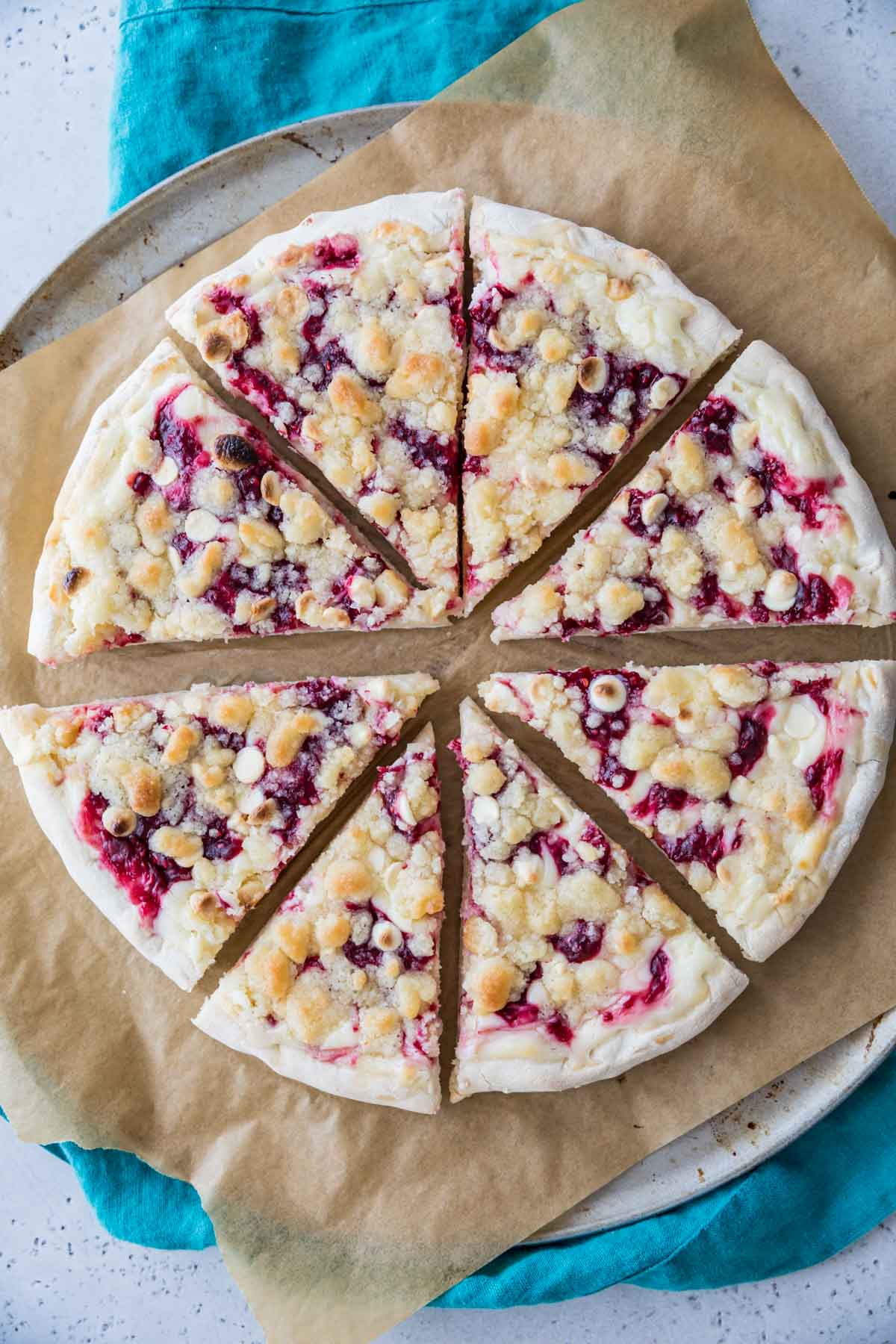 Overhead view of a raspberry pizza that's been cut into 8 slices.
