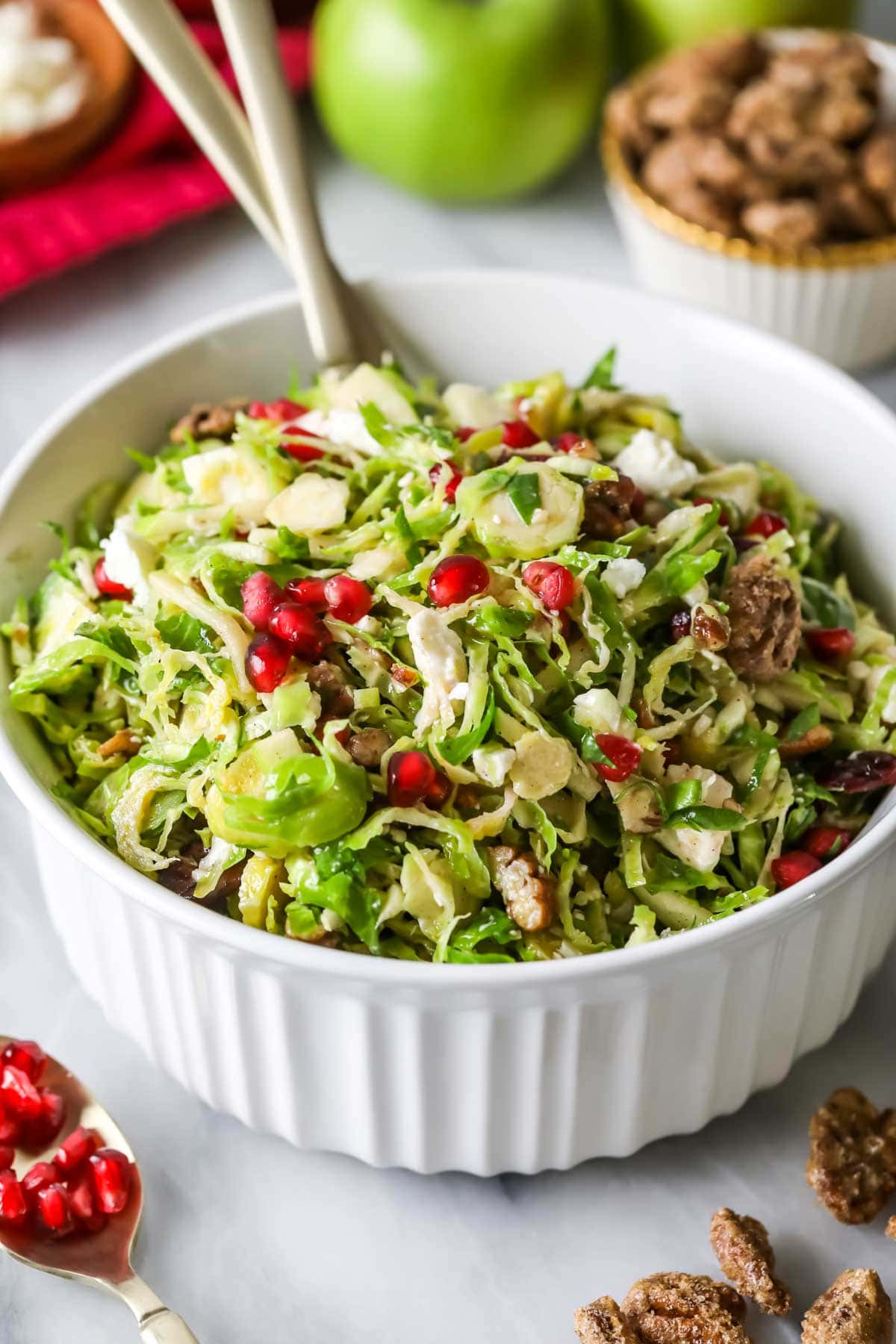 Close-up shot of a shaved brussels sprouts salad topped with pomegranate arils.