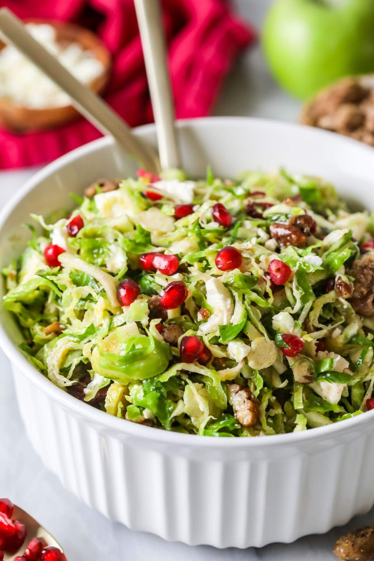 Close-up shot of a shaved brussels sprouts salad topped with pomegranate arils.