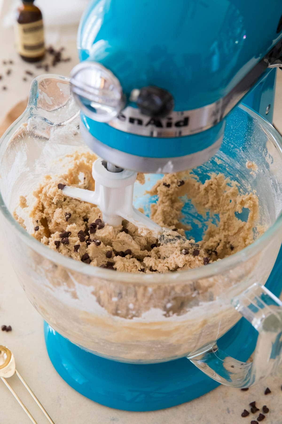 Blue stand mixer with cookie dough in the bowl.