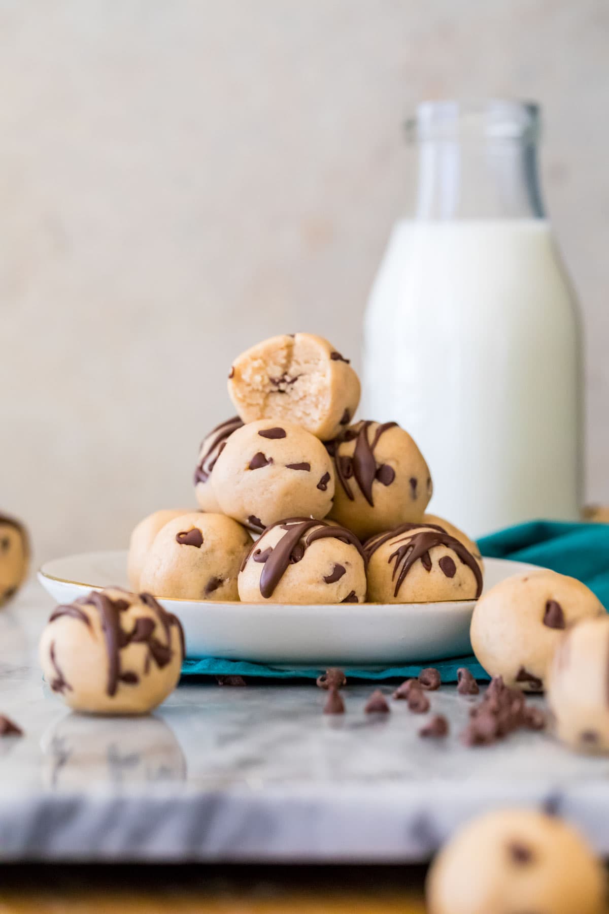 Stacked pile of round cookie dough balls with the top missing a bite.
