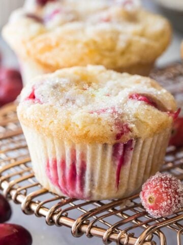 Cranberry muffins with sugared tops on a cooling rack.