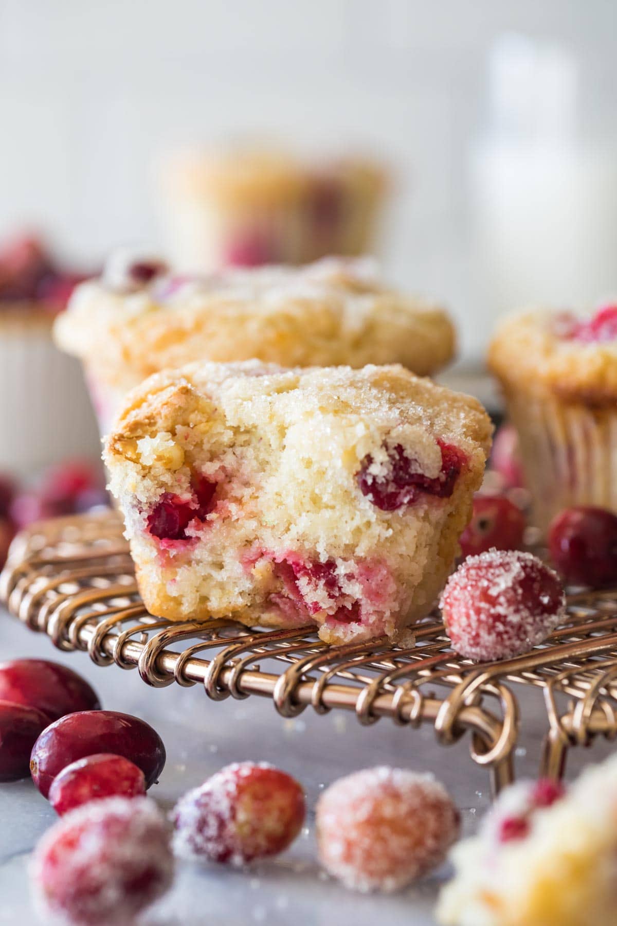 Muffin that's been bitten in half to show a fluffy texture and fresh cranberries.