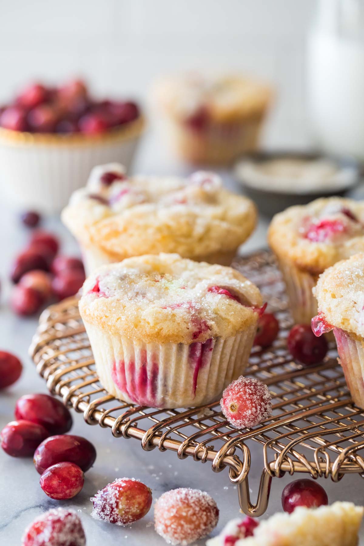 Cranberry muffins with sugared tops on a cooling rack.