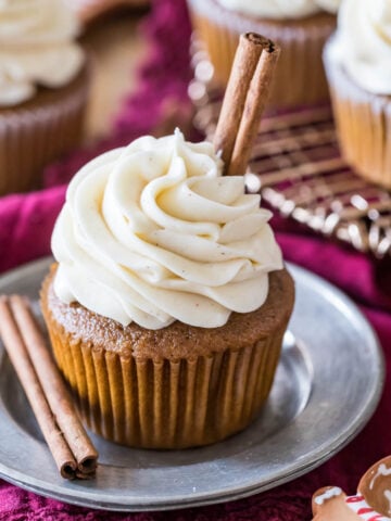 Gingerbread cupcake topped with a brown sugar cream cheese frosting and cinnamon sticks.