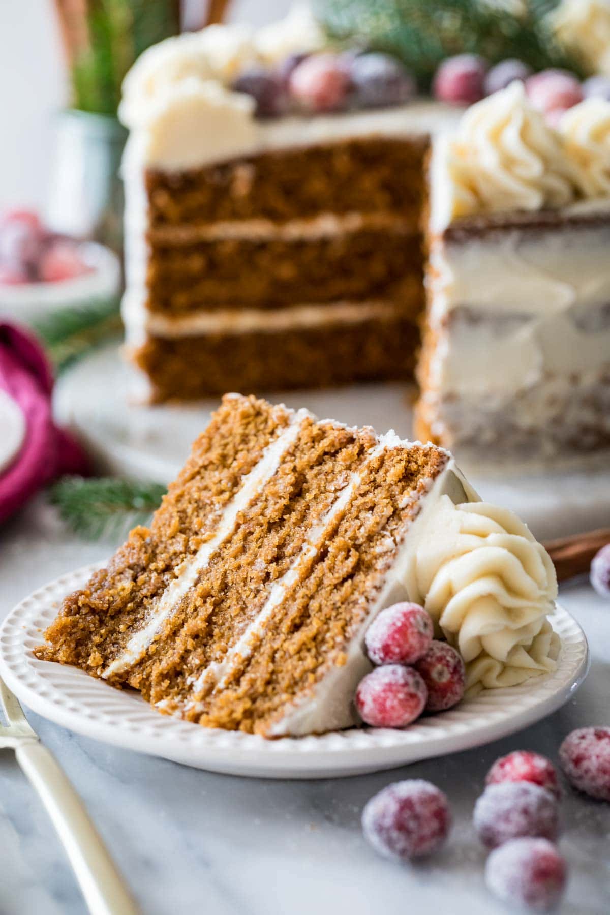 Slice of gingerbread cake cut from a three layer cake in the background.