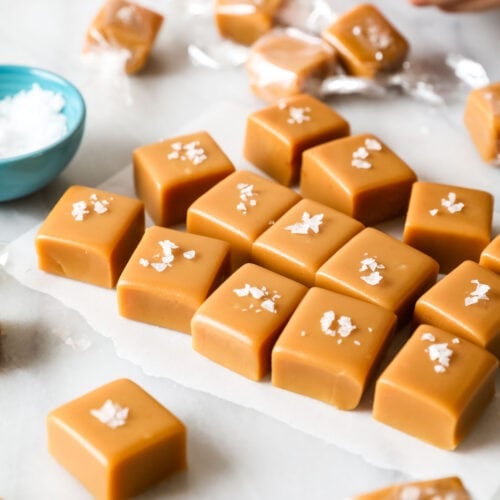 Squares of homemade caramel candy topped with flaky sea salt.
