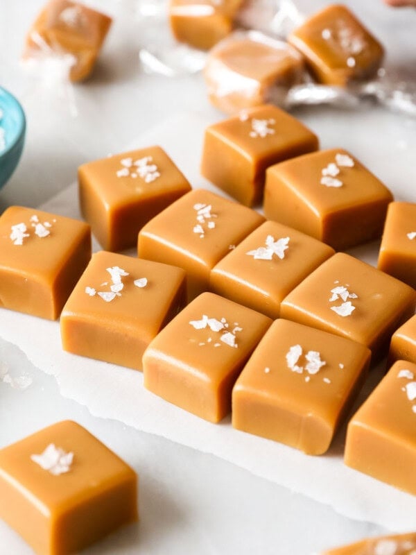 Squares of homemade caramel candy topped with flaky sea salt.