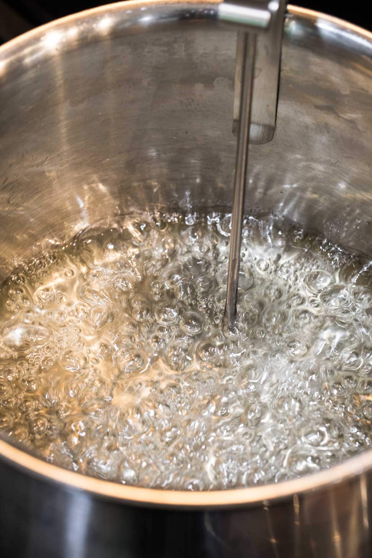 Candy mixture boiling in a stainless steel pot.