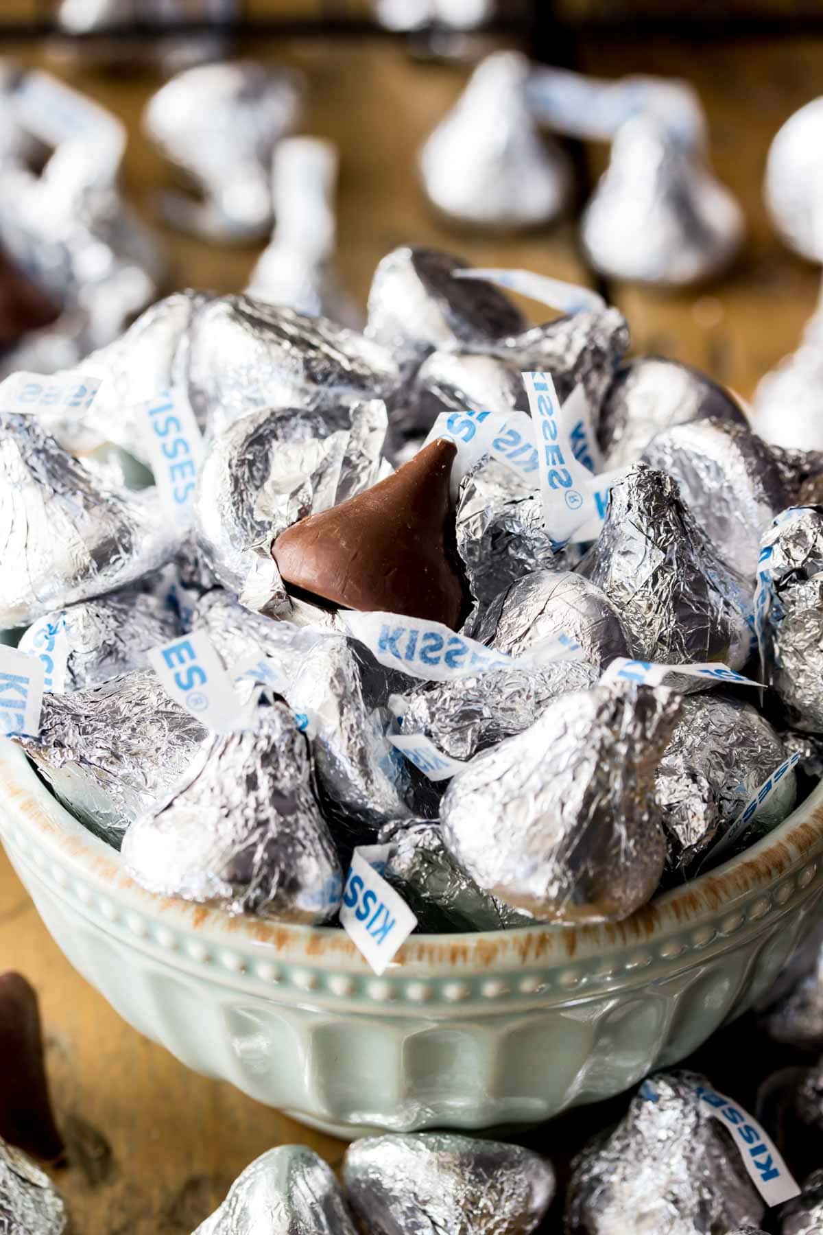 Bowl of Hershey kisses, with the top kiss missing its wrapper.