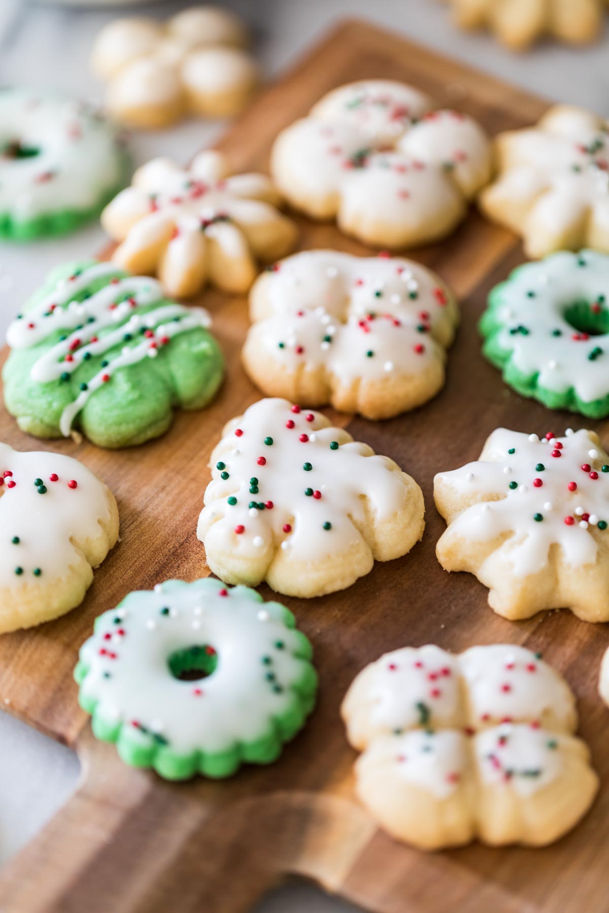 Close-up view of spritz cookies that have been decorated with glaze and red and green nonpareils.