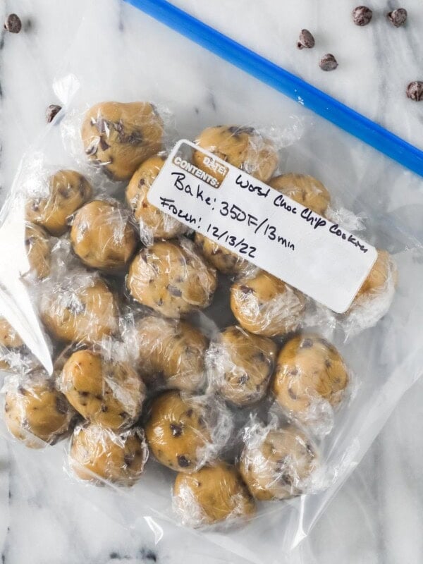 Ziploc bag of cookie dough balls that have been wrapped in plastic in preparation for freezing.