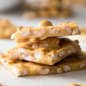 Three pieces of peanut brittle stacked on top of each other vertically.