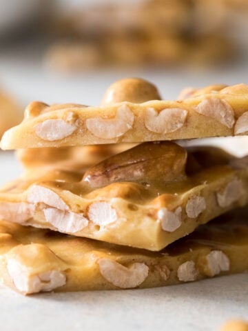 Three pieces of peanut brittle stacked on top of each other vertically.