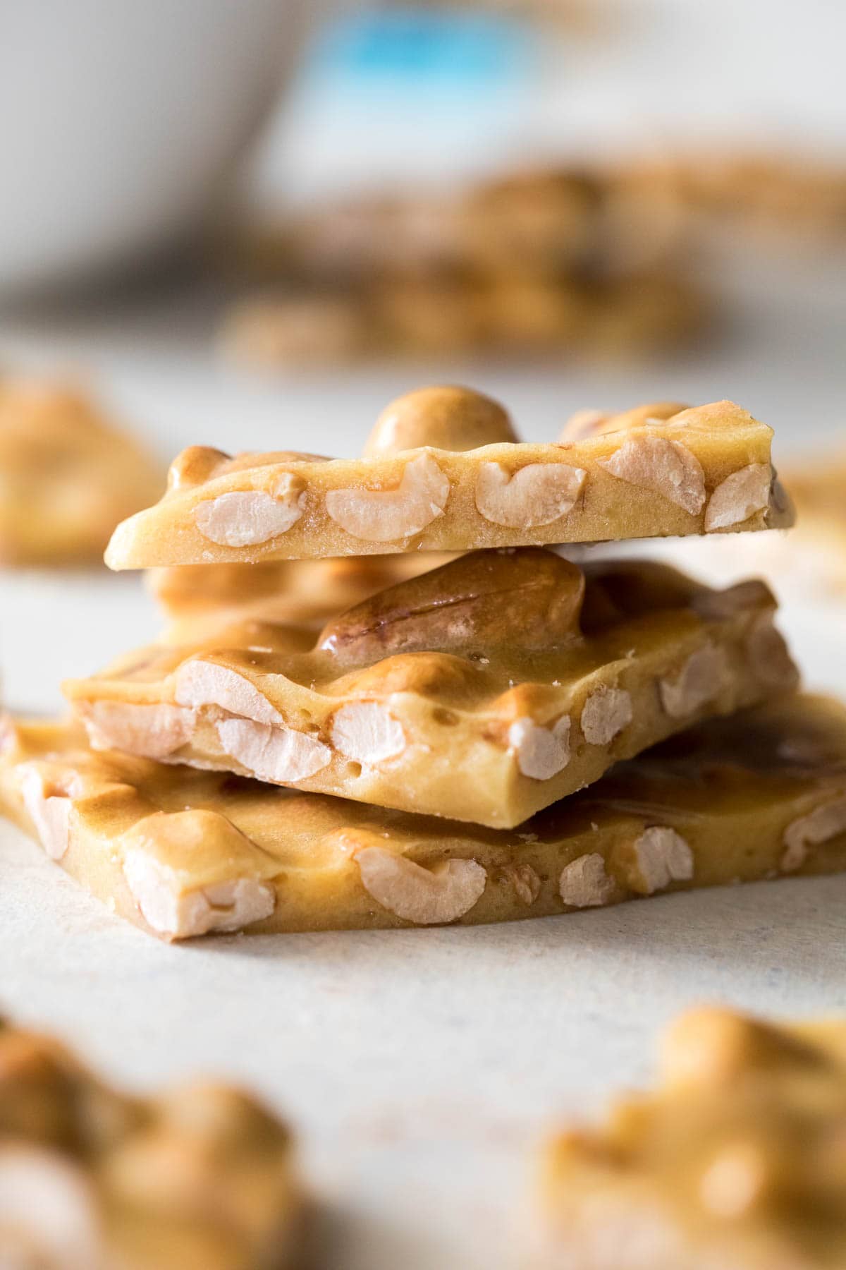 Three pieces of peanut brittle stacked on top of each other vertically.