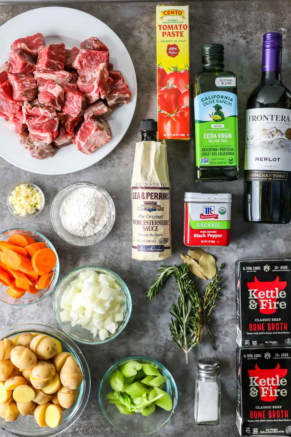 Overhead view of ingredients including beef, carrots, potatoes, celery, red wine, and more.