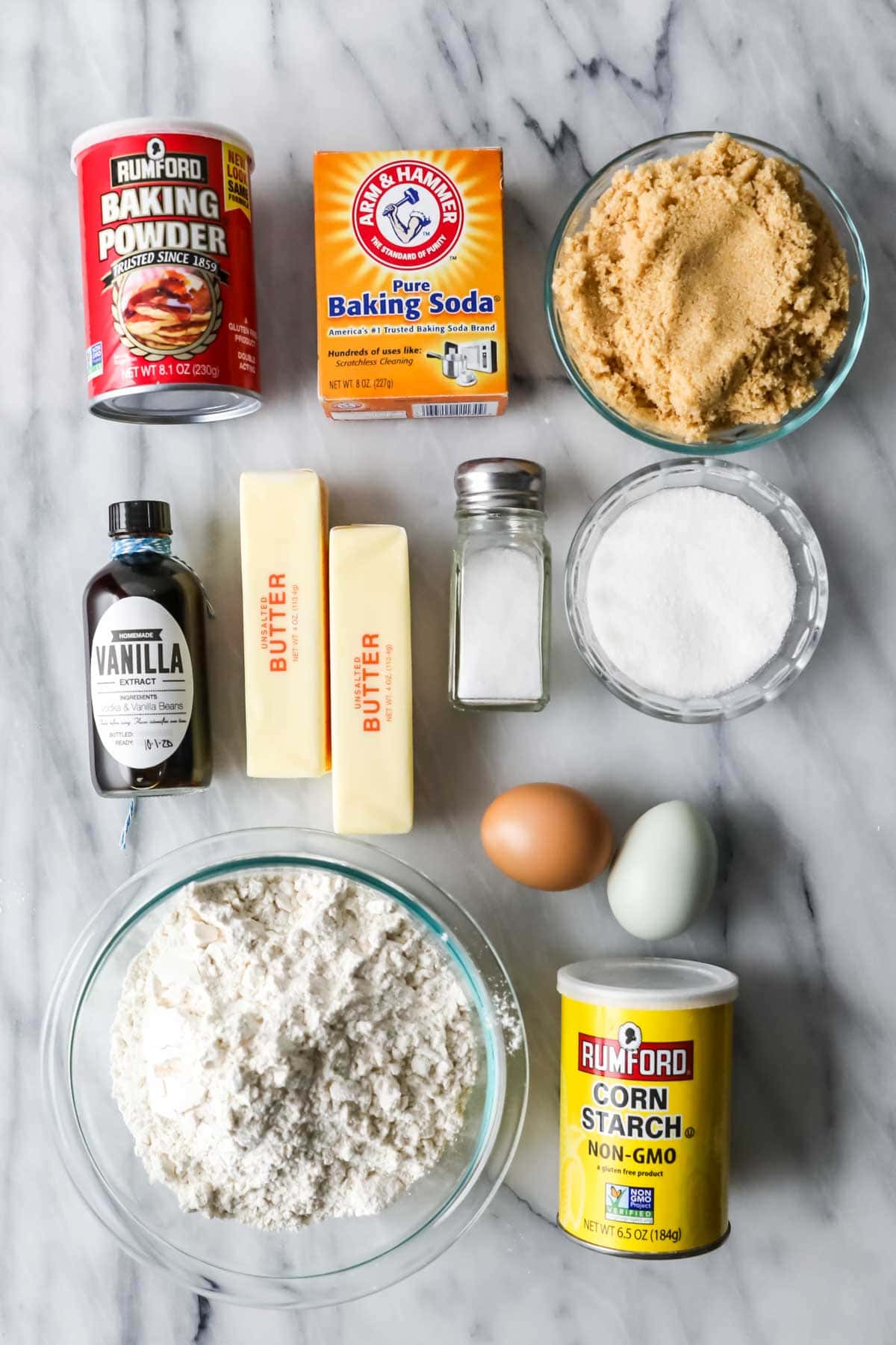 Overhead view of ingredients including brown sugar, flour, vanilla, butter, and more.