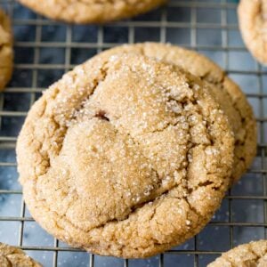 Sparkly brown sugar cookies with crackled tops on a metal cooling rack.