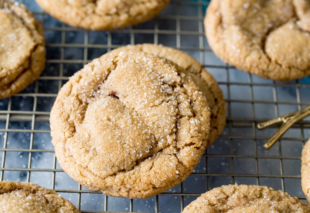 Sparkly brown sugar cookies with crackled tops on a metal cooling rack.