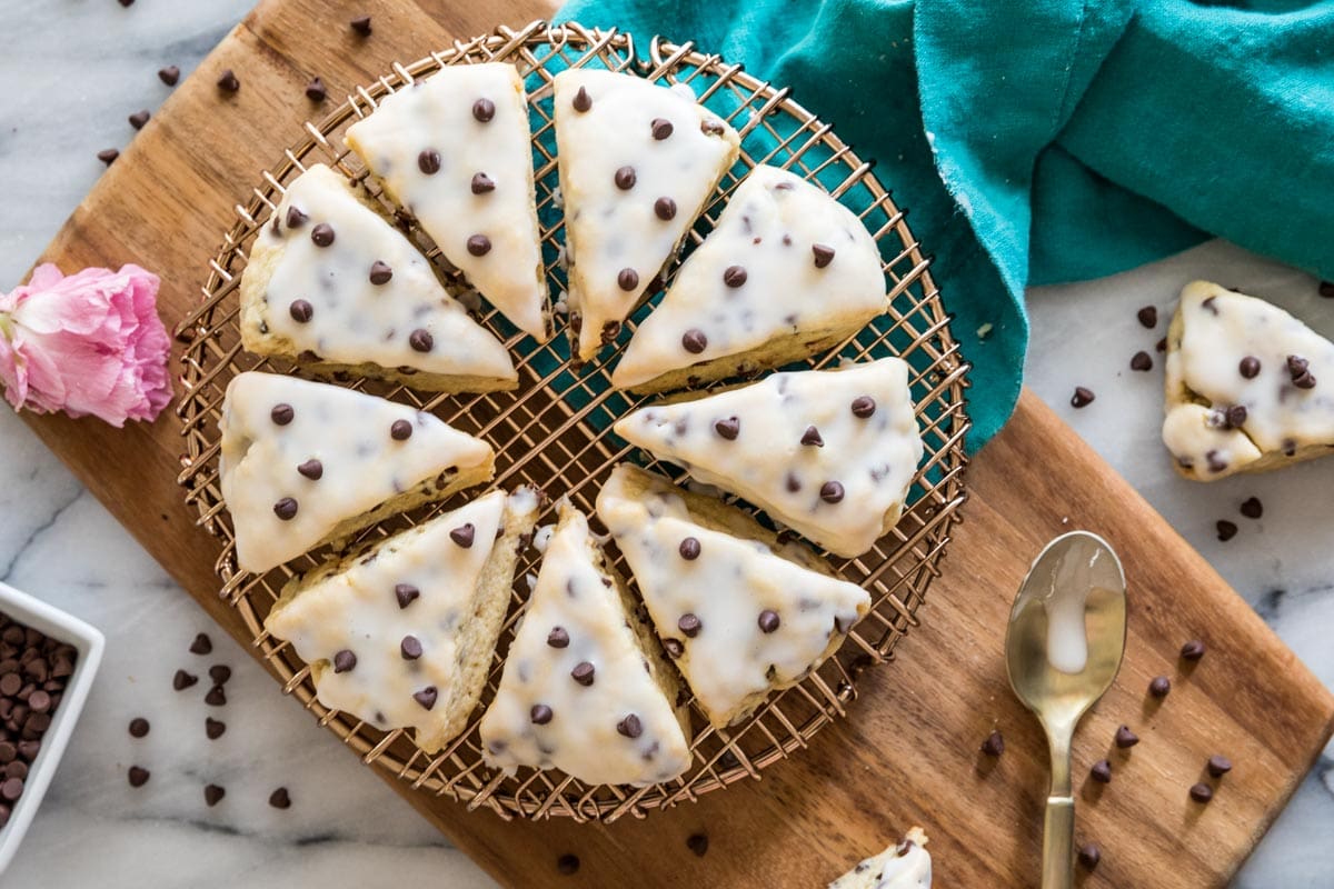 Overhead view of scones topped with vanilla glaze and chocolate chips arranged in a circle.