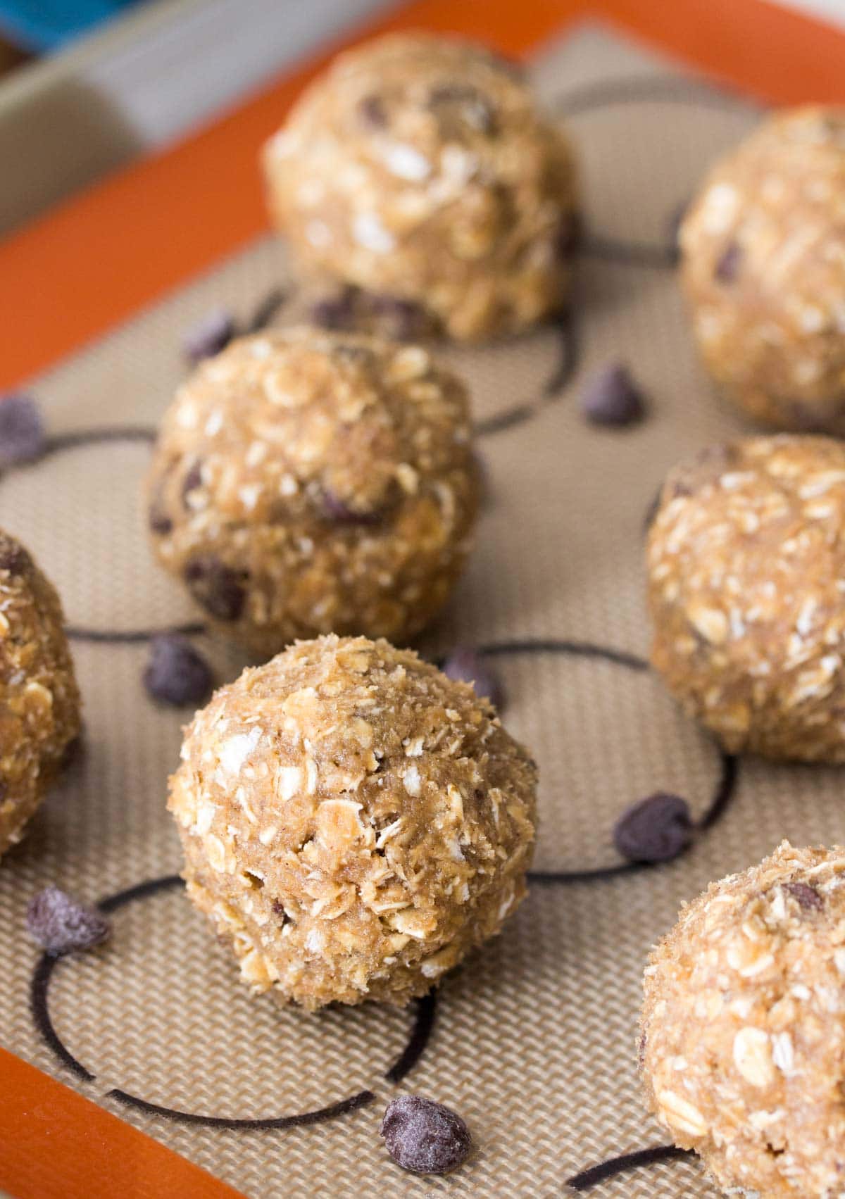 Balls of oatmeal cookie dough on a baking sheet.