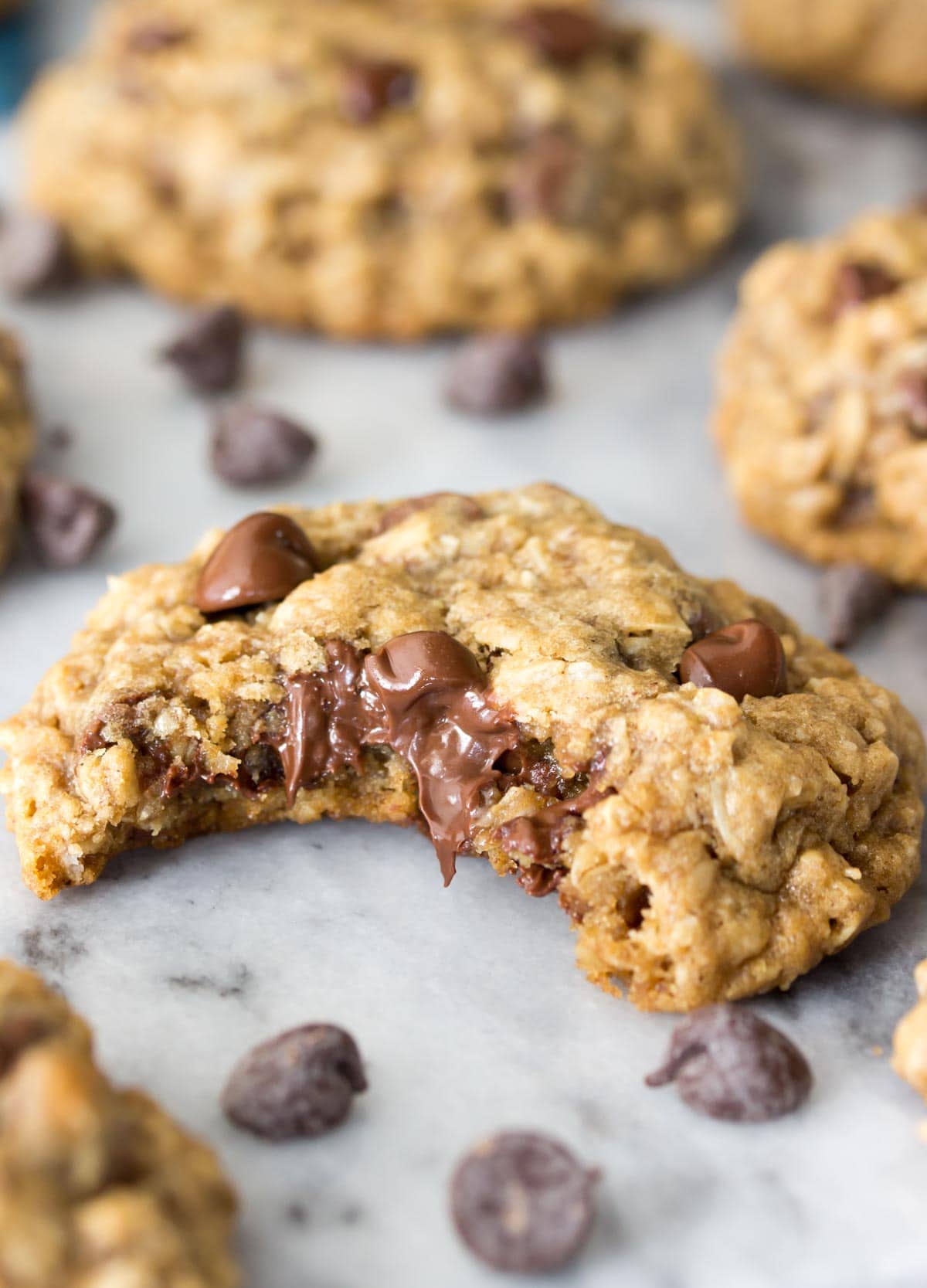 Oatmeal cookie that's been bitten into to show lots of melty chocolate chips.