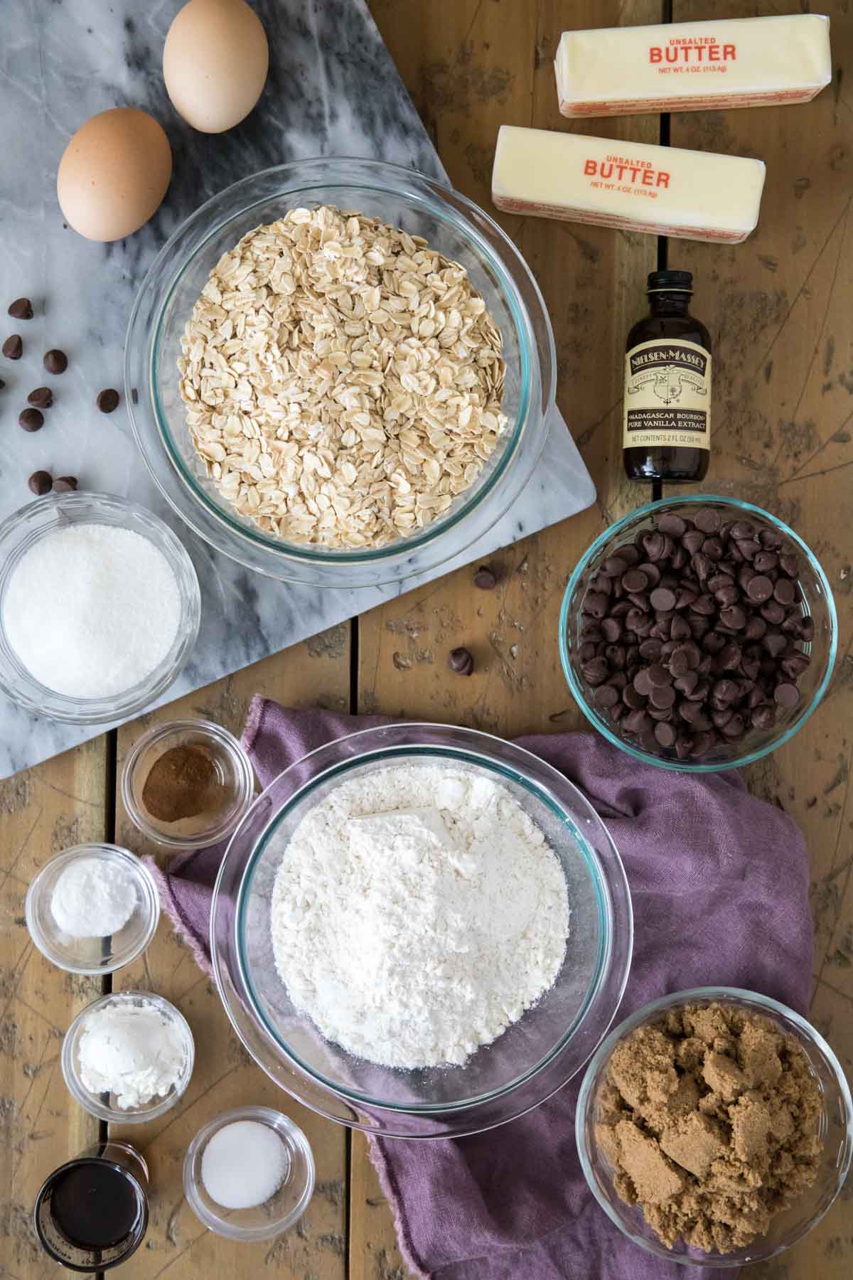 Overhead view of ingredients including oats, chocolate chips, flour, vanilla, and more.