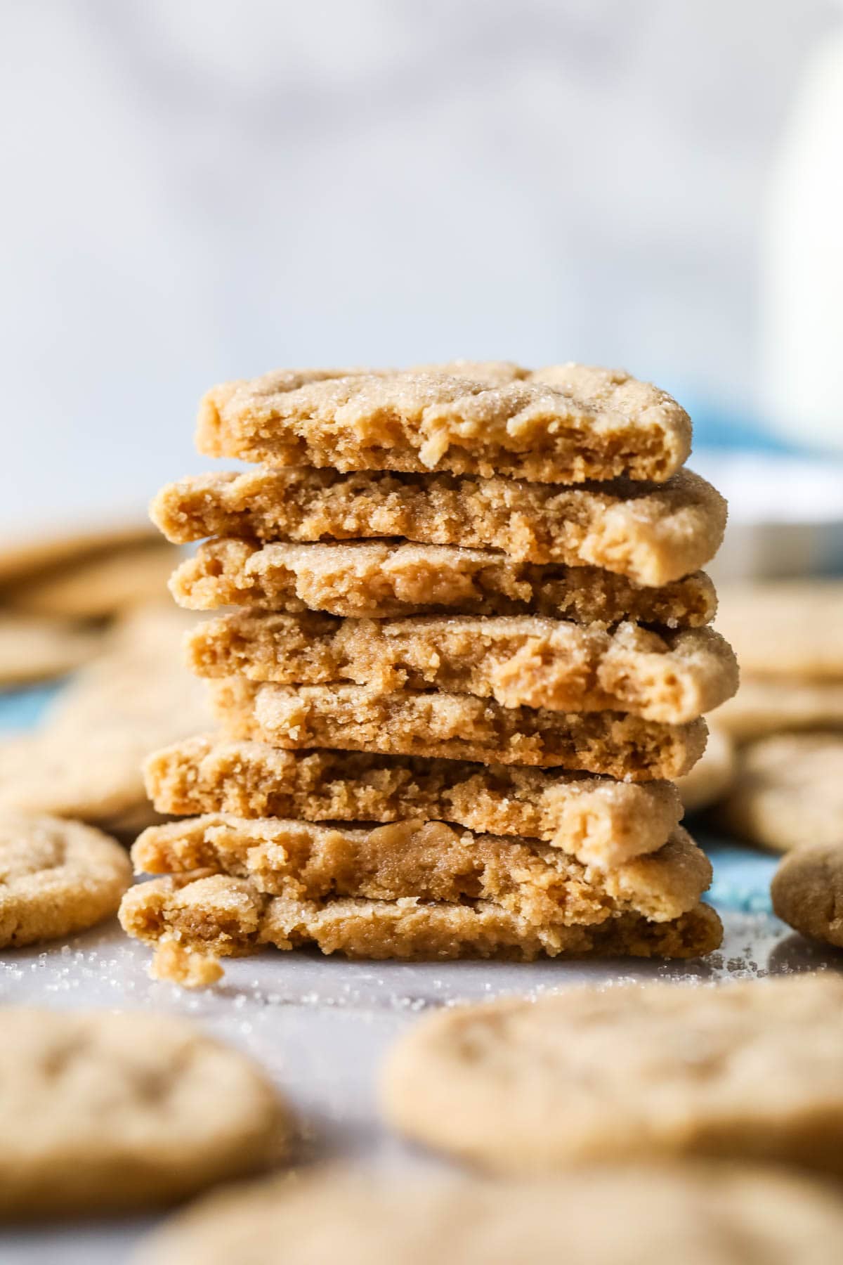 Stack of peanut butter crinkle cookies halved to shown their texture.