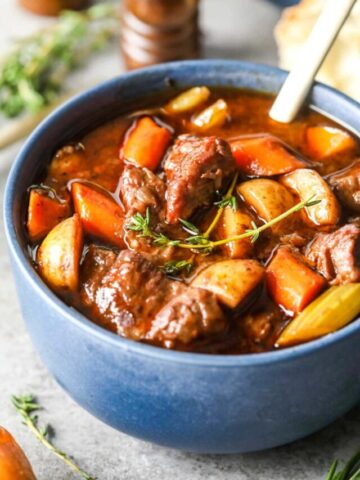 Image of Beef stew in blue bowl with spoon.