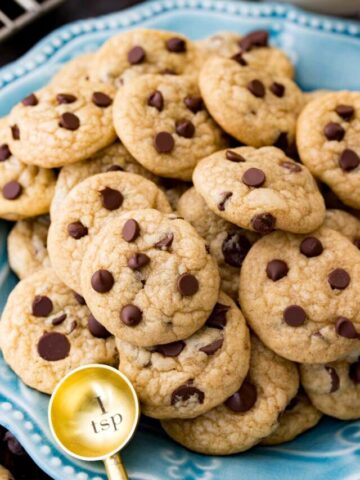 Image of mini chocolate chip cookies served on blue platter with gold teaspoon spoon