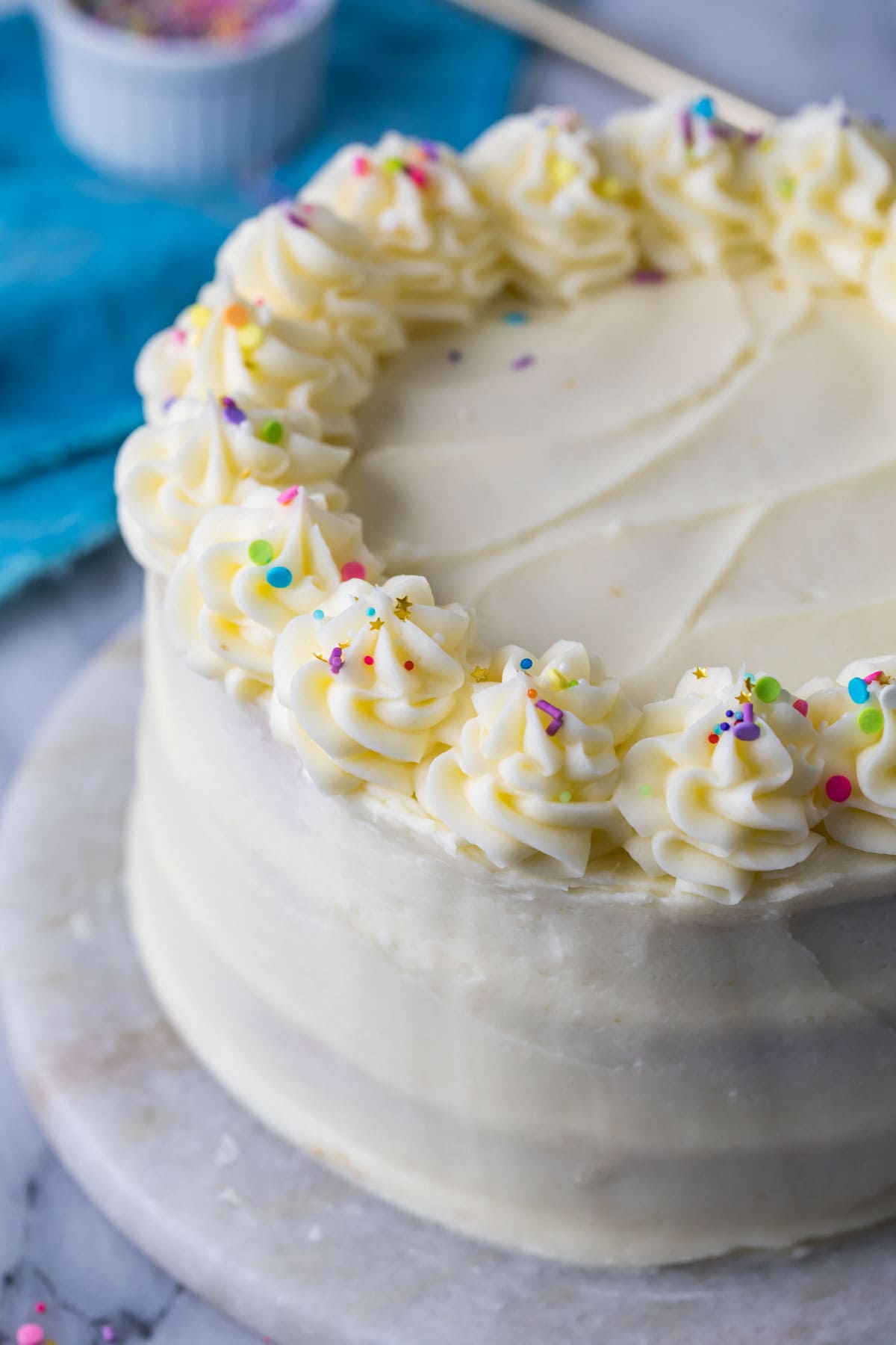 Cake topped with swirls of white icing and sprinkles.