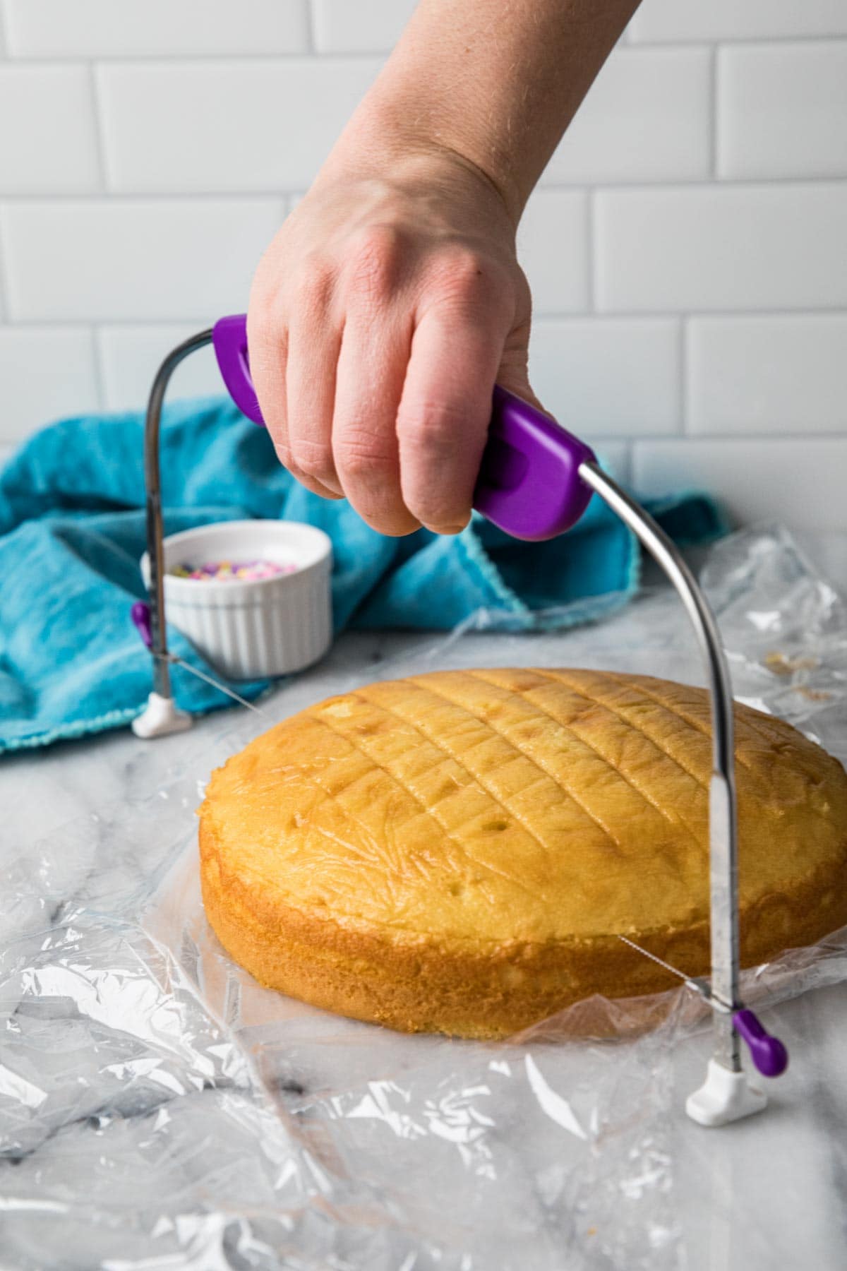 Yellow cake being leveled with a cake leveler.